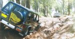 a Nissan being winched by a Toyota up a rutted sidesloping hill (Click for large version)