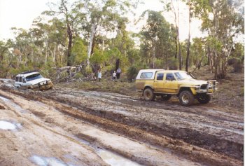 Hilux about to recover a bogged cruiser